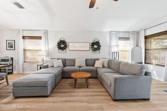 living room with plenty of natural light, lofted ceiling, visible vents, and ceiling fan