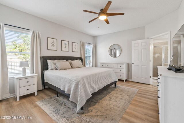 bedroom with light wood-style flooring, multiple windows, and a ceiling fan