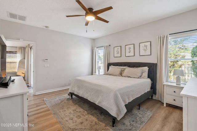 bedroom with visible vents, ceiling fan, light wood-type flooring, and baseboards