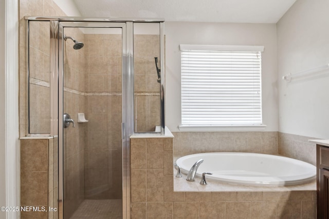 bathroom with a shower stall, vanity, and a garden tub