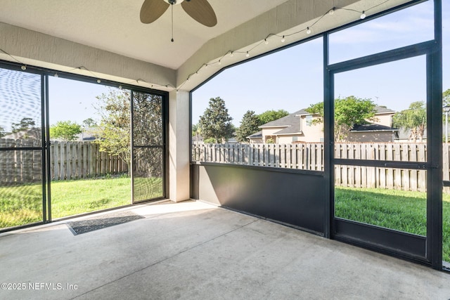 unfurnished sunroom featuring ceiling fan