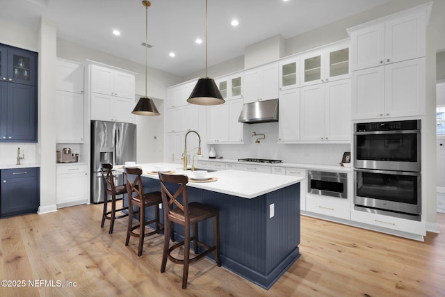 52 Sunshine Bass Ct, Ponte Vedra, FL 32081 - kitchen with a sink, stainless steel appliances, a kitchen breakfast bar, tasteful backsplash, and light wood-type flooring