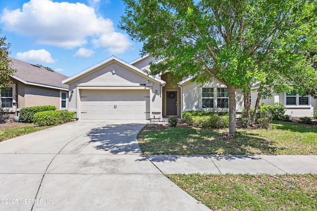 view of front of home featuring a garage, stucco siding, and concrete driveway