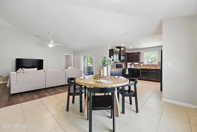 dining space with a healthy amount of sunlight, baseboards, and vaulted ceiling