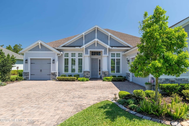 441 Anthem Ridge Dr, Ponte Vedra, FL 32081 - craftsman house featuring an attached garage, a shingled roof, stone siding, and decorative driveway