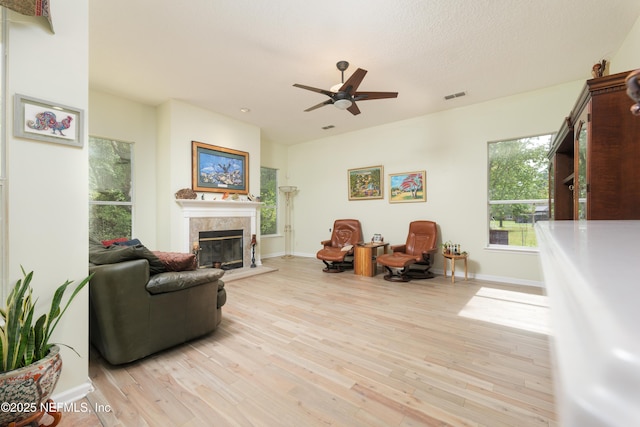 13772 Chipperfield Ln, Jacksonville, FL 32226 - living area with a premium fireplace, a ceiling fan, light wood-style flooring, baseboards, and visible vents