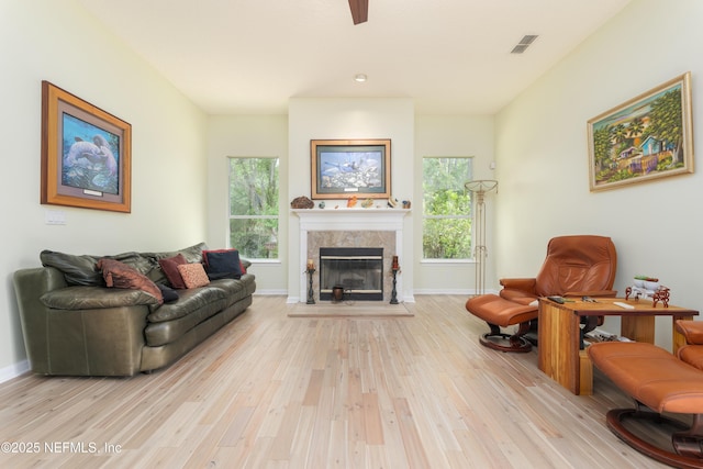 13772 Chipperfield Ln, Jacksonville, FL 32226 - living room featuring wood finished floors, visible vents, a ceiling fan, baseboards, and a tiled fireplace