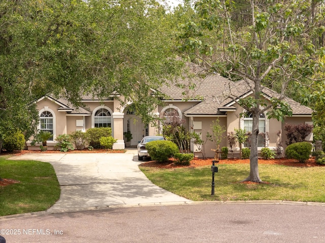 13772 Chipperfield Ln, Jacksonville, FL 32226 - mediterranean / spanish home featuring stucco siding, driveway, a shingled roof, and a front yard