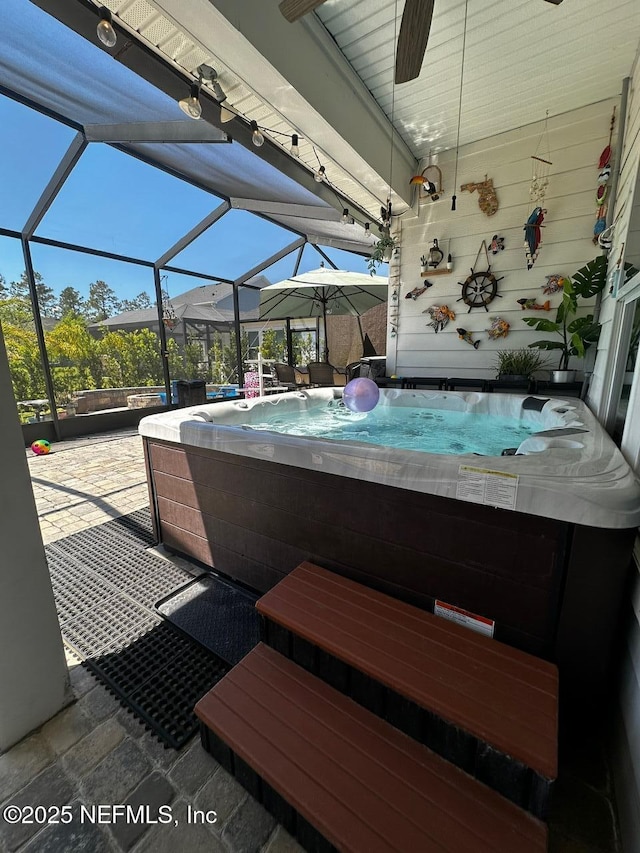 view of patio / terrace with a lanai and a hot tub