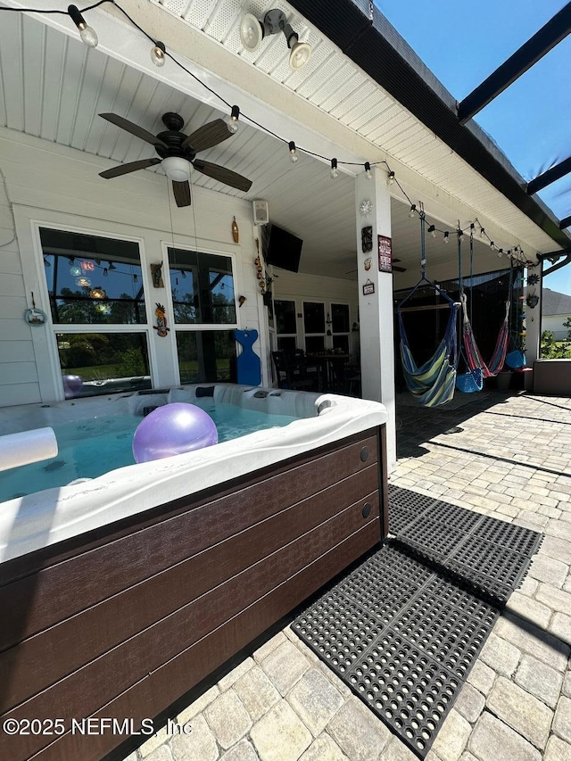 view of patio featuring ceiling fan and a hot tub