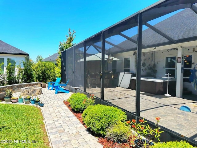 view of patio / terrace with a fire pit, a jacuzzi, and a lanai
