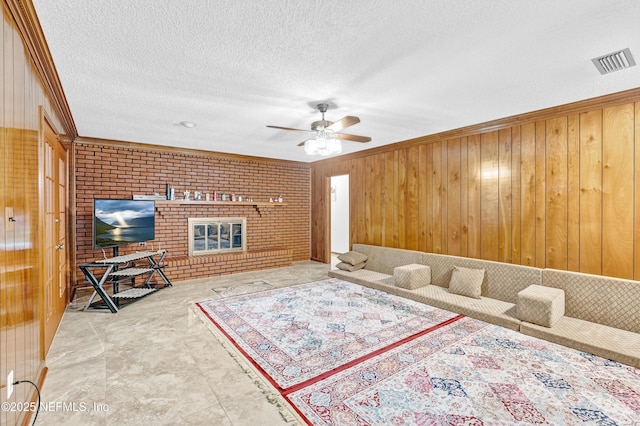 6982 Madrid Ave, Jacksonville, FL 32217 - living area with ornamental molding, wooden walls, a textured ceiling, visible vents, and ceiling fan