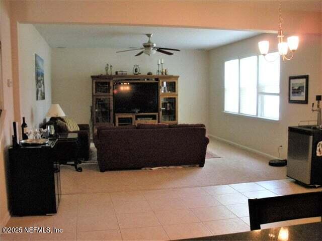 46 Molasses Ct, Jacksonville, FL 32259 - living room featuring light tile patterned floors, baseboards, light colored carpet, and ceiling fan with notable chandelier