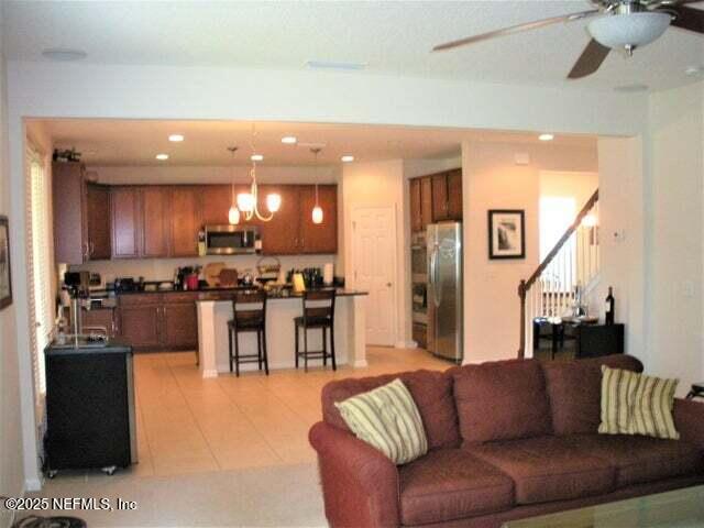 46 Molasses Ct, Jacksonville, FL 32259 - living area with ceiling fan with notable chandelier, light tile patterned floors, stairway, and recessed lighting