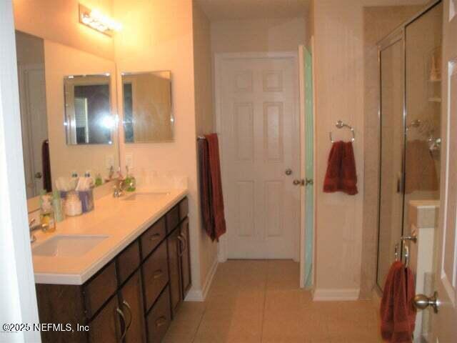 46 Molasses Ct, Jacksonville, FL 32259 - bathroom featuring a shower stall, a sink, tile patterned flooring, and baseboards