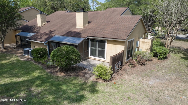 765 Sea Oats Bay, Ponte Vedra Beach, FL 32082 - back of house featuring a chimney, roof with shingles, a lawn, central AC, and stucco siding