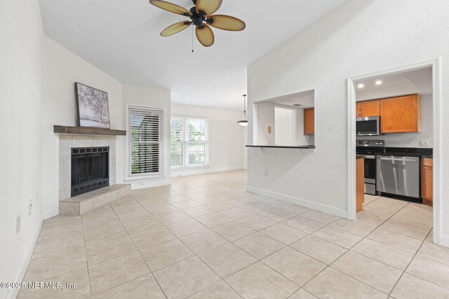 810 Sandpiper Ln, Ponte Vedra Beach, FL 32082 - unfurnished living room with a tiled fireplace, a ceiling fan, baseboards, and light tile patterned floors