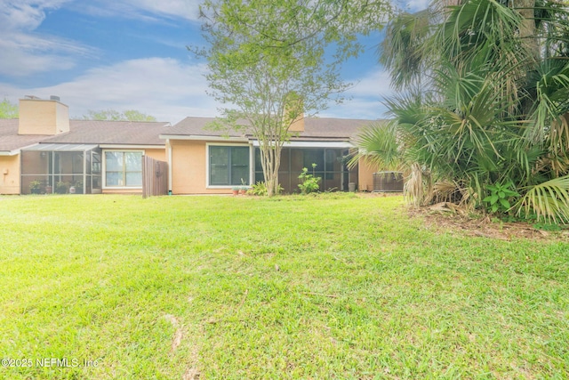 810 Sandpiper Ln, Ponte Vedra Beach, FL 32082 - back of house featuring a sunroom, a chimney, a yard, and stucco siding