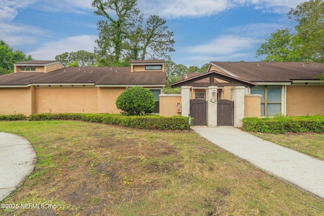 810 Sandpiper Ln, Ponte Vedra Beach, FL 32082 - view of front of house with fence private yard, a front yard, stucco siding, a gate, and driveway