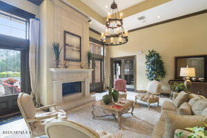 810 Sandpiper Ln, Ponte Vedra Beach, FL 32082 - living room with an inviting chandelier, a fireplace with raised hearth, and crown molding