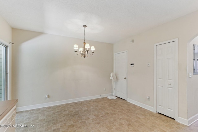 unfurnished dining area featuring arched walkways, baseboards, and a notable chandelier