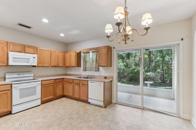 kitchen featuring an inviting chandelier, light countertops, visible vents, a sink, and white appliances