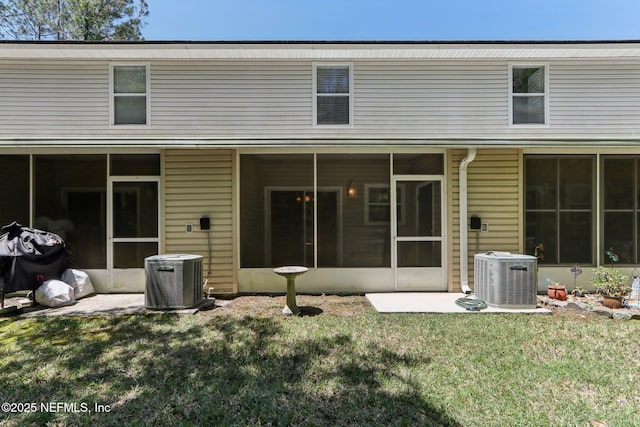 back of house with a lawn, a sunroom, and central air condition unit