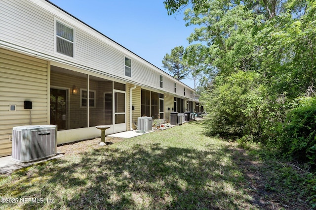 view of yard with a sunroom and central AC unit