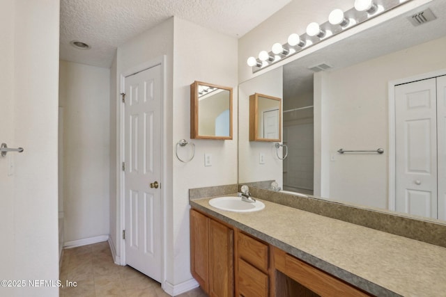 full bathroom featuring tile patterned floors, visible vents, a textured ceiling, and vanity
