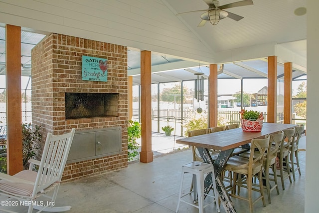 view of patio / terrace with fence, a ceiling fan, and an outdoor brick fireplace