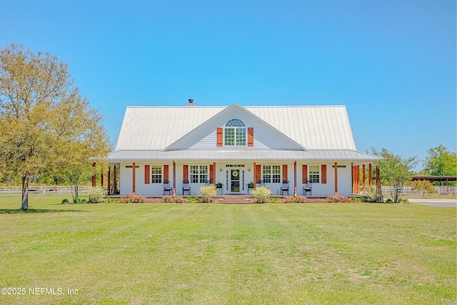 farmhouse featuring a porch, a front yard, and metal roof