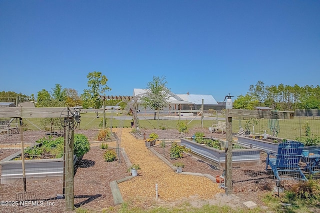 view of yard featuring fence and a vegetable garden