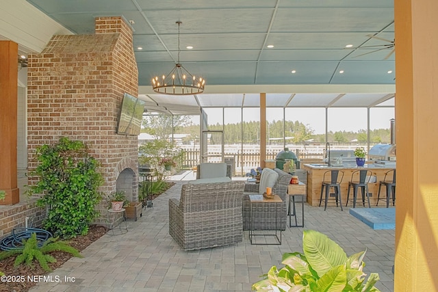 view of patio / terrace with a lanai, outdoor dry bar, fence, and a sink