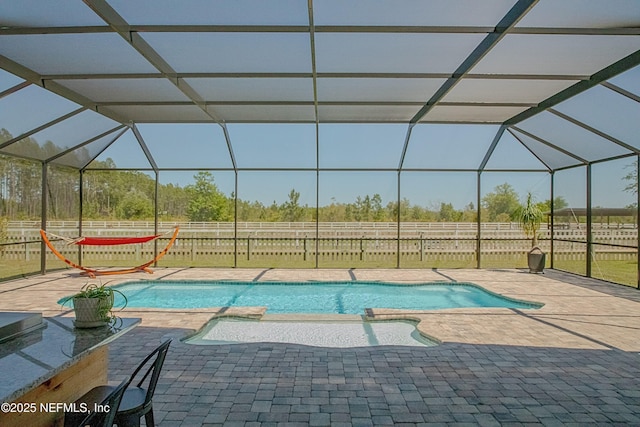 view of pool featuring a patio area, a fenced backyard, glass enclosure, and a pool with connected hot tub