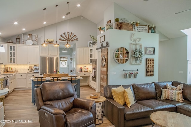 living area featuring high vaulted ceiling and light wood finished floors