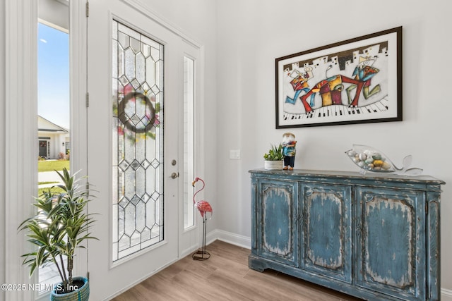 foyer featuring baseboards and wood finished floors