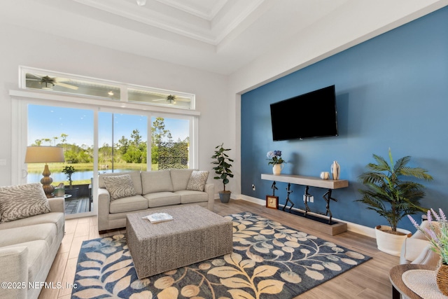 living room with crown molding, baseboards, and wood finished floors