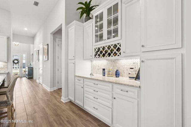 bar with visible vents, tasteful backsplash, wood finished floors, baseboards, and recessed lighting
