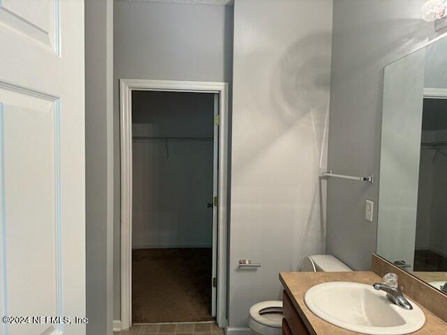 12301 Kernan Forest Blvd Unit 302, Jacksonville, FL 32225 - bathroom with toilet, a spacious closet, and vanity