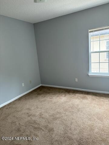 12301 Kernan Forest Blvd Unit 302, Jacksonville, FL 32225 - unfurnished room with carpet floors, baseboards, and a textured ceiling