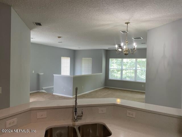 12301 Kernan Forest Blvd Unit 302, Jacksonville, FL 32225 - kitchen featuring a sink, an inviting chandelier, a textured ceiling, and visible vents