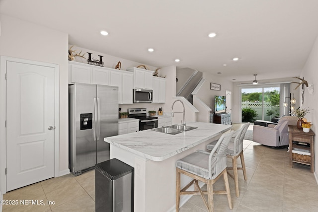 3937 Oak Mill Rd, Orange Park, FL 32065 - kitchen with light tile patterned floors, white cabinets, a center island with sink, stainless steel appliances, and a sink