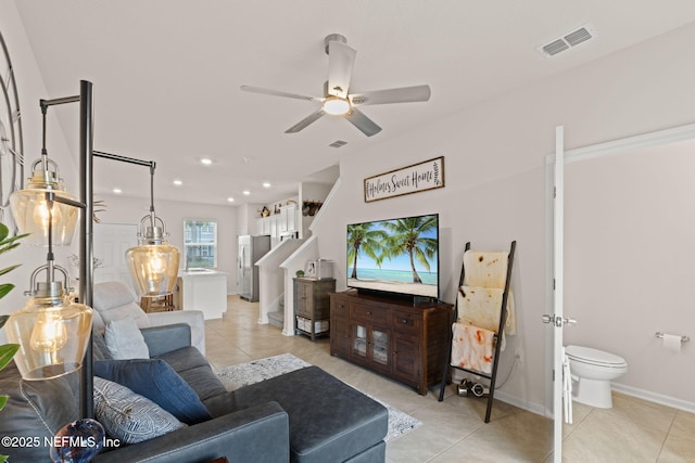 3937 Oak Mill Rd, Orange Park, FL 32065 - living area with visible vents, light tile patterned floors, baseboards, ceiling fan, and stairs