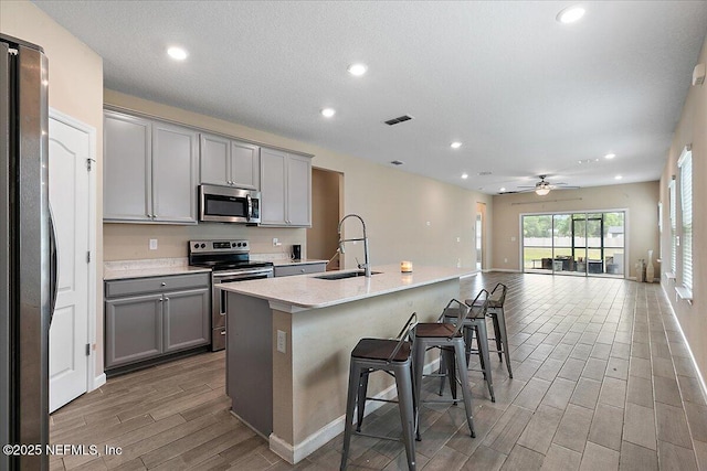 2176 Major Oak St, Jacksonville, FL 32218 - kitchen with a sink, stainless steel appliances, gray cabinets, visible vents, and wood finish floors