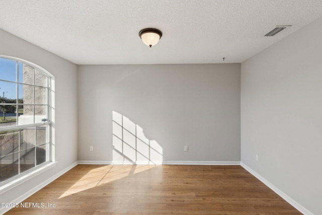 2423 Royal Pointe Dr, Green Cove Springs, FL 32043 - spare room with visible vents, baseboards, and wood finished floors