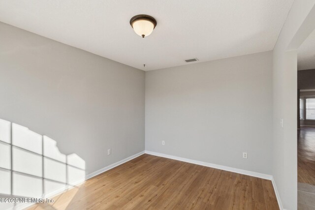 2423 Royal Pointe Dr, Green Cove Springs, FL 32043 - unfurnished room with visible vents, baseboards, and wood finished floors