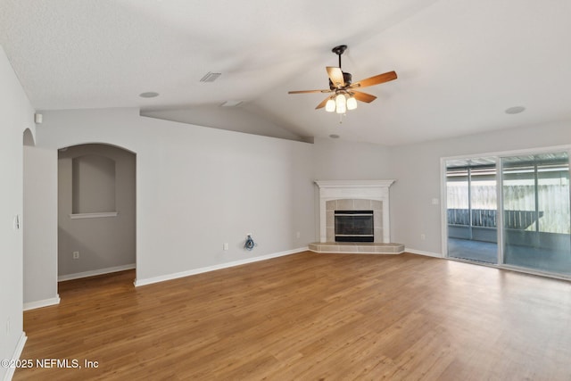2423 Royal Pointe Dr, Green Cove Springs, FL 32043 - unfurnished living room featuring baseboards, light wood-style flooring, a ceiling fan, lofted ceiling, and a tile fireplace