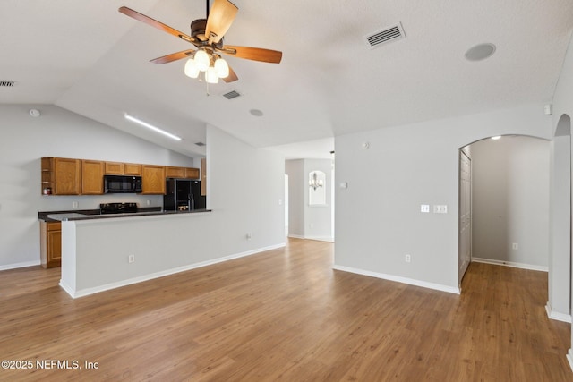 2423 Royal Pointe Dr, Green Cove Springs, FL 32043 - unfurnished living room featuring arched walkways, lofted ceiling, visible vents, and light wood-type flooring