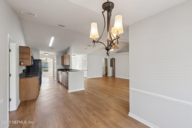2423 Royal Pointe Dr, Green Cove Springs, FL 32043 - kitchen featuring arched walkways, a notable chandelier, light wood-style flooring, and dark countertops