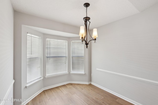 2423 Royal Pointe Dr, Green Cove Springs, FL 32043 - unfurnished dining area featuring a chandelier, light wood-type flooring, and baseboards